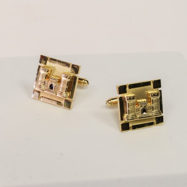 Two gold cuff links with a gold raised Army engineer castle design.